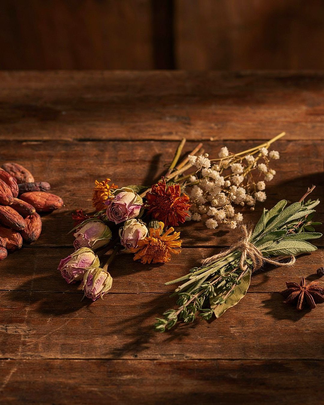 Cacau, ervas e flores sobre madeira